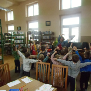 W bibliotece. Grupa dzieci tańczy w rytm muzyki.