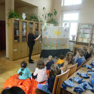 W bibliotece. Grupa dzieci ogląda teatrzyk.