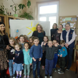 Wnętrze biblioteki. Zdjęcie grupowe dzieci uczestniczących w spotkaniu.