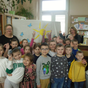 Wnętrze biblioteki. Zdjęcie grupowe dzieci uczestniczących w spotkaniu.