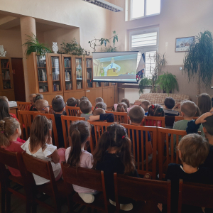 W bibliotece. Grupa dzieci ogląda film.