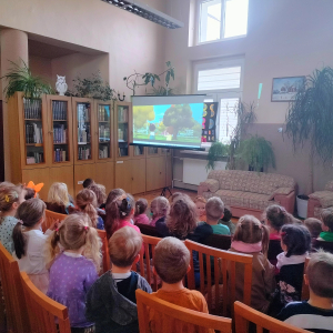 W bibliotece. Grupa dzieci ogląda film.