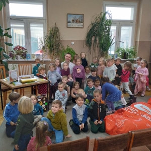 W bibliotece. Grupa dzieci wraz z prowadzącym spotkanie ustawiła się do wspólnego zdjęcia.