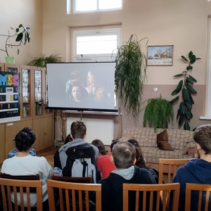 W bibliotece. Grupa osób ogląda film.