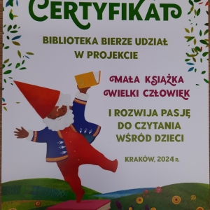 Plakat informujący o udziale biblioteki w projekcie Mała książka-wielki człowiek. Na nim krasnal trzyma książkę.