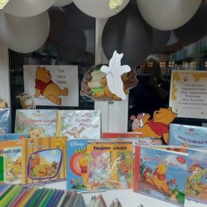W bibliotece. Na parapecie ustawione książki. 