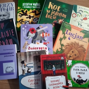 W bibliotece. Na stole leżą książki.