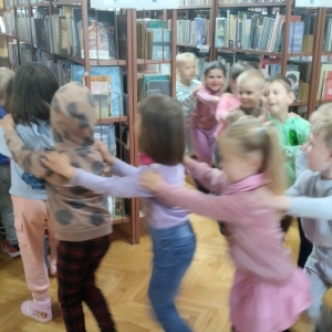 W bibliotece. Dzieci bawią się w tzw. węża i zwiedzaja bibliotekę.