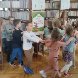 W bibliotece. Dzieci bawią się w tzw. węża i zwiedzaja bibliotekę.