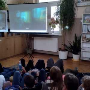 W bibliotece. Grupa dzieci ogląda film.