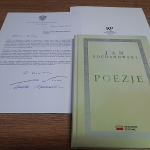 Na stoliku leży książka i list z podziękowaniami za wzięcie udziału w Narodowym Czytaniu.