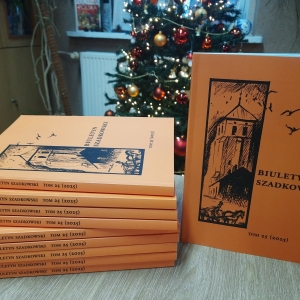 Na stoliku ułożone książki, których okładki są koloru pomarańczowego.