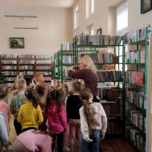 Grupa dzieci zwiedza bibliotekę.