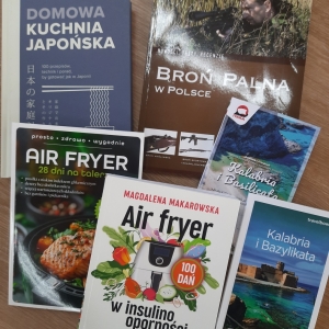 W bibliotece. Na stoliku ułożone książki. 