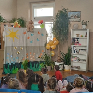 W bibliotece. Udekorowana scena. Dzieci oglądają kukiełkowy teatrzyk.