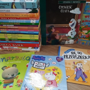 W bibliotece. Na stoliku ułożone książki. 