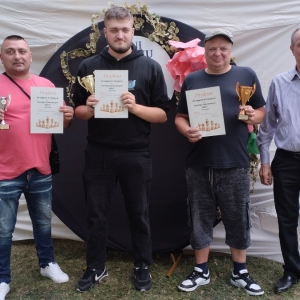 W plenerze. Uczestnicy turnieju szachowego ustawili się do wspólnego zdjęcia. Z dumą prezentują zdobyte puchary.